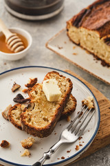Banana bread. Freshly baked homemade banana pie with honey and butter on a light gray background
