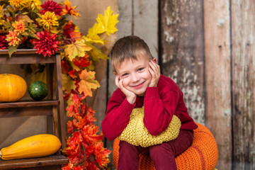 a boy in a red sweater with a yellow pumpkin
