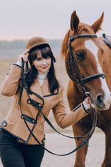 First lessons of horseback riding. Young beautiful girl riding a horse in a field.