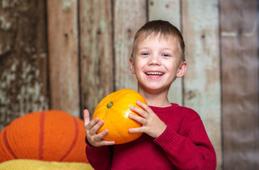 a boy in a red sweater with a orange pumpkin
