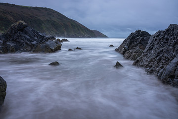 Obraz premium Ebbing tide exposing a rocky coast line in the morning light