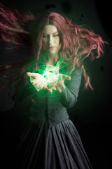 Victorian witch holding a glowing orb. This is a digitally composited image