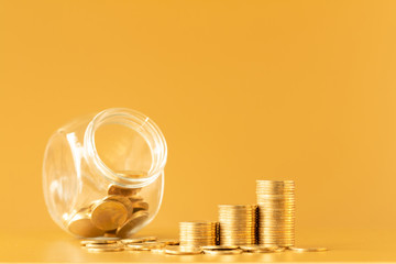 Jar bank and stack gold coins in the office, Saving money for future investment concept.