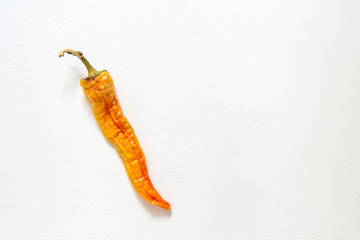 Wrinkled ugly peppers lie on a white background