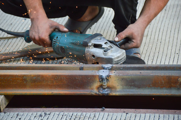 Worker grinds welded rail joint