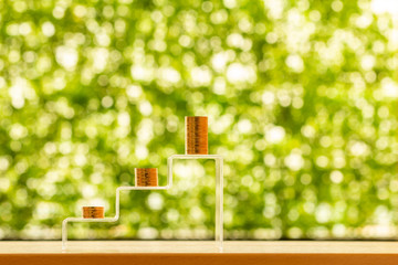 .Stacked gold coin with growing value of deposit put on the crystal staircase put on the desk in the office , Saving money for future investment concept.
