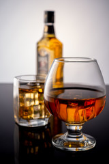 Bottle of whiskey and a glass of whiskey with ice