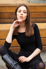 Obraz na płótnie Canvas Young beautiful woman sitting on a bench
