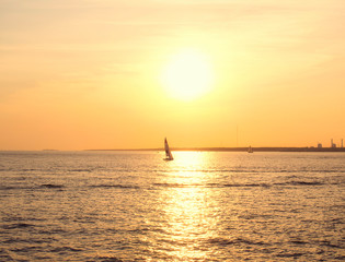 Naklejka na ściany i meble Sailing boat on the sea at sunset.