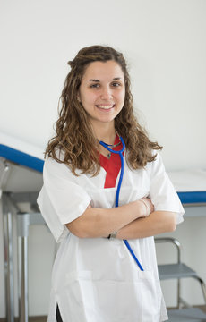 Young smiling caucasian nurse with stethoscope in her hand in the infirmary