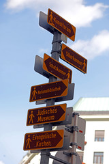 Viele Schilder als Wegweiser mit Pfeilen zu Sehenswürdigkeiten in Wien wie Kunstforum,...