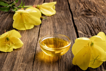 Evening primrose oil and fresh blooming plant