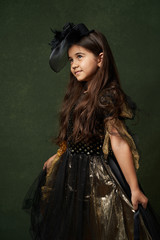 Cute child girl in witch costume for Halloween, close-up
