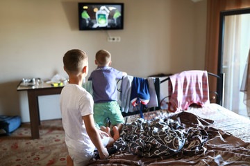 Boys watching TV on bed
