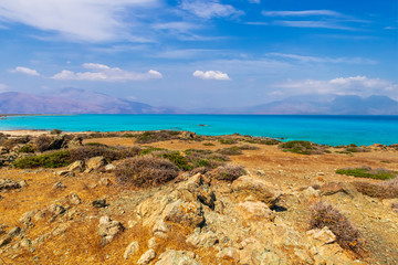 Fototapeta na wymiar abandoned beach , rocks on coast, beautiful turquoise sea , deep blue sky with clouds and mountains on background, Mediterranean landscape