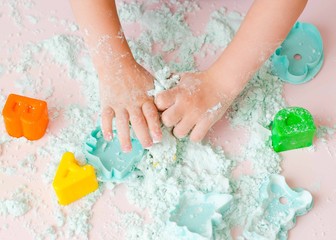 Childs hands with sand. kid play kinetic sand.  Magic sand. Close up