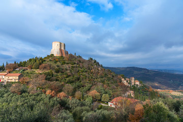 Fototapeta na wymiar Amazing landscape of the Tuscan countryside with the medieval fortress Rocca of Tentennano on the hill in winter.