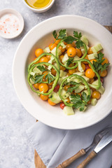 Salad with cucumber, tomato cherry,  onion and paprika. Top view on grey concrete background.