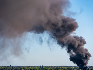 Thick black smoke from junkyard  steel fire