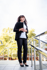 Portrait of young caucasian lawyer outdoors holding black document folder