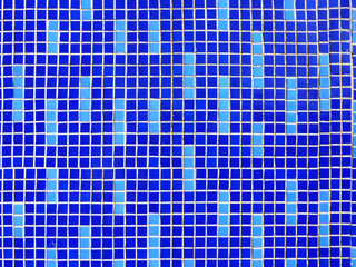 Fragment of a wall lined with ceramic tiles in blue and cyan