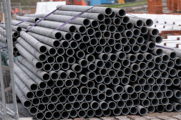 Metal pipes in a warehouse, closeup of photo. Stack of new and shiny steel pipe in factory