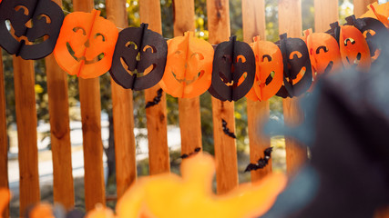 Paper garland decoration for halloween on wooden fence © Viktoriia