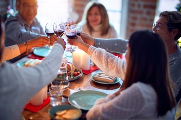 Family and friends dining at home celebrating christmas eve with traditional food and decoration, all sitting on the table together