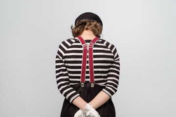 Sad young mime woman turning back being offended. Studio shot