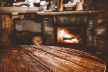 Wooden top with cosy warm home interior with fireplace background.