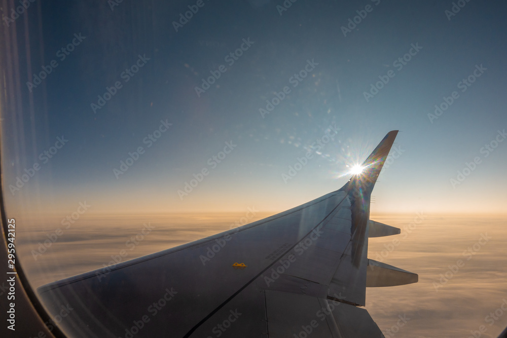 Wall mural the right wing of the plane rises into the blue sky