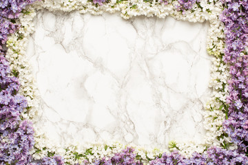 Purple and white lilac flowers on marble background, simple composition with spring flower