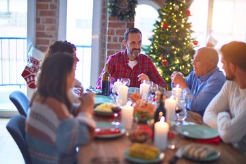 Beautiful family smiling happy and confident. Eating roasted turkey celebrating Christmas at home