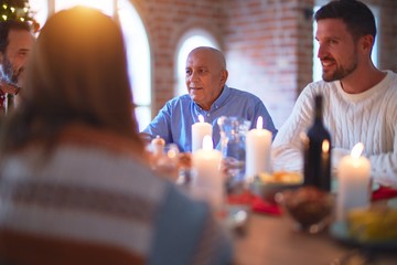 Beautiful family smiling happy and confident. Eating roasted turkey celebrating Christmas at home