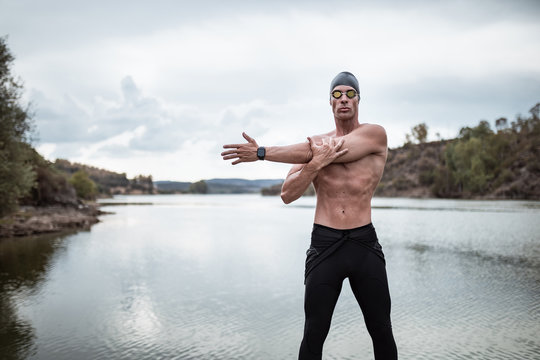 swimmer in swimsuit glasses and cap in open water