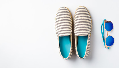 Summer vacation concept flat lay. Summer shoes and sunglasses, top view.