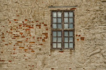 Wall of an old building made of brick and stone. There is an old wooden window on the wall. Background. Savonlinna, Finland