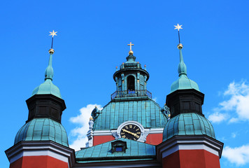 Domes of the Church of St. James in Stockholm. Cross and stars on a background of blue sky.
