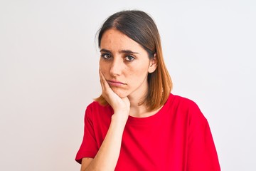 Fototapeta premium Beautiful redhead woman wearing casual red t-shirt over isolated background thinking looking tired and bored with depression problems with crossed arms.