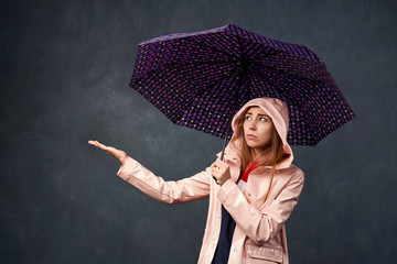 Girl in raincoat from rain, holding an umbrella