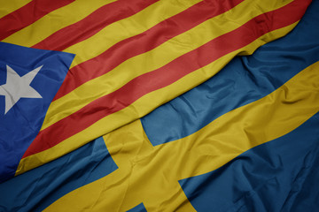 waving colorful flag of sweden and national flag of catalonia.