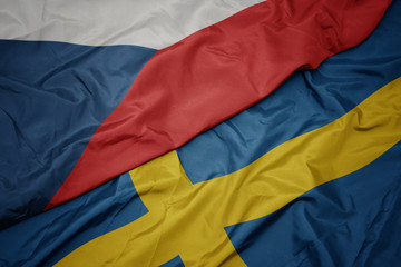waving colorful flag of sweden and national flag of czech republic.