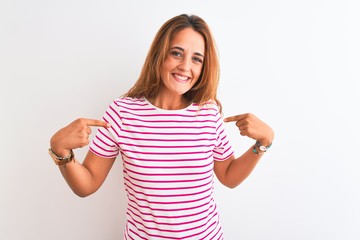 Young redhead woman wearing striped casual t-shirt stading over white isolated background looking confident with smile on face, pointing oneself with fingers proud and happy.