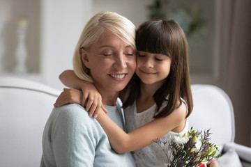 Happy mature grandmother bonding little adorable granddaughter.