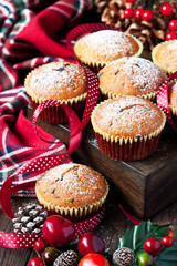 Christmas muffins covered powdered sugar on wooden table