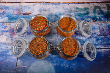 Fragrant spices in a glass jar with a lid and a metal lock on a wooden table.
