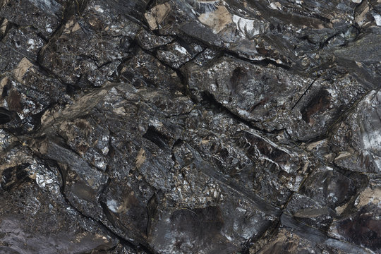 Close-up view of coal mine. Raw coal ore surface close-up. Natural black coal bar for background. Industrial coal nuggets close up.
