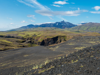 Icelandic lava desert landscape with view on Tindfjallajokull glacier mountain peak. Fjallabak Nature Reserve, Iceland. Summer blue sky
