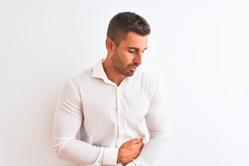 Young handsome business man wearing elegant shirt over isolated background with hand on stomach because nausea, painful disease feeling unwell. Ache concept.