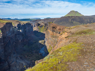 View on majestic Markarfljotsgljufur Canyon gorge and river with green hills and Hattafell mountain near Botnar camp at Fjallabak Nature Reserve in Highlands of Iceland, blue sky background